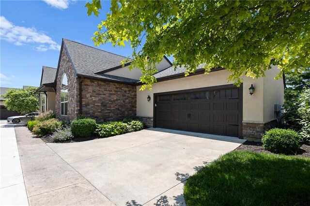 8230 W 131st Ct, Overland Park, KS 66213 - view of front facade featuring stone siding, driveway, a garage, and stucco siding