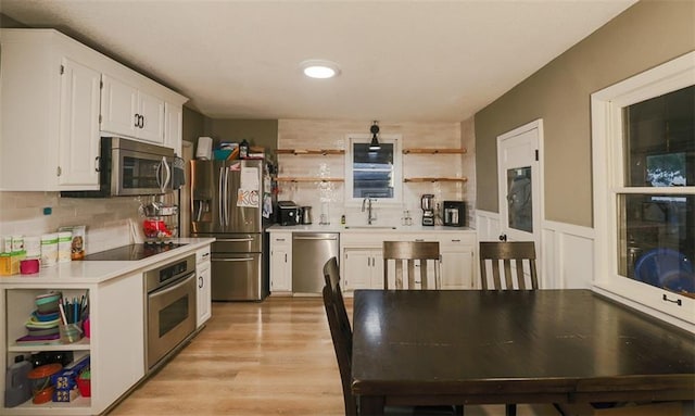 300 Brown Ave, Osawatomie, KS 66064 - kitchen featuring appliances with stainless steel finishes, open shelves, light countertops, white cabinetry, and decorative backsplash