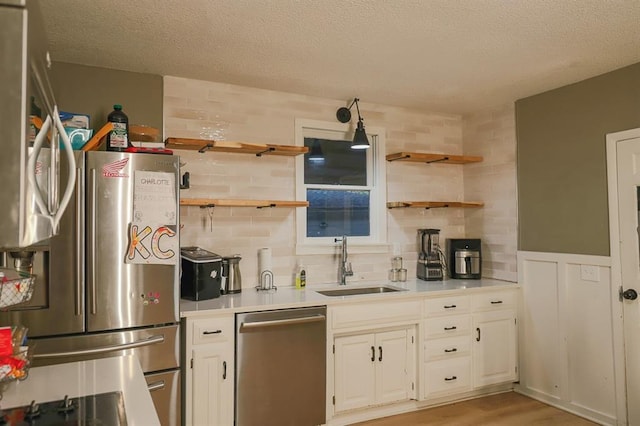 300 Brown Ave, Osawatomie, KS 66064 - kitchen featuring stainless steel appliances, open shelves, a textured ceiling, white cabinets, and light countertops