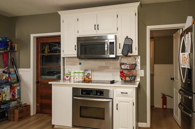 300 Brown Ave, Osawatomie, KS 66064 - kitchen featuring appliances with stainless steel finishes, light wood-style flooring, white cabinetry, and light countertops
