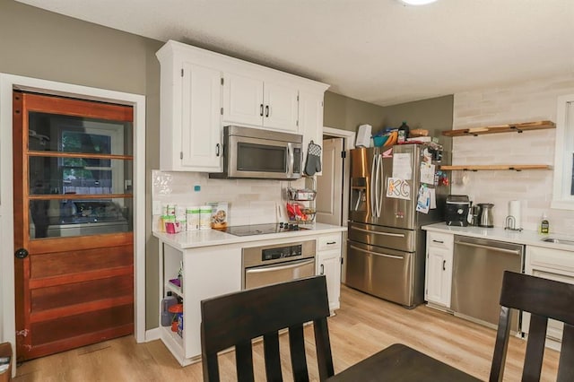 300 Brown Ave, Osawatomie, KS 66064 - kitchen featuring stainless steel appliances, light countertops, light wood-style floors, white cabinetry, and backsplash