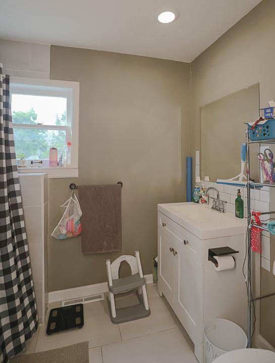 300 Brown Ave, Osawatomie, KS 66064 - bathroom featuring tile patterned floors, vanity, and curtained shower