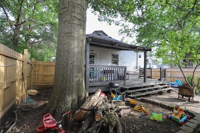 300 Brown Ave, Osawatomie, KS 66064 - back of property featuring an outdoor fire pit, a fenced backyard, and a wooden deck