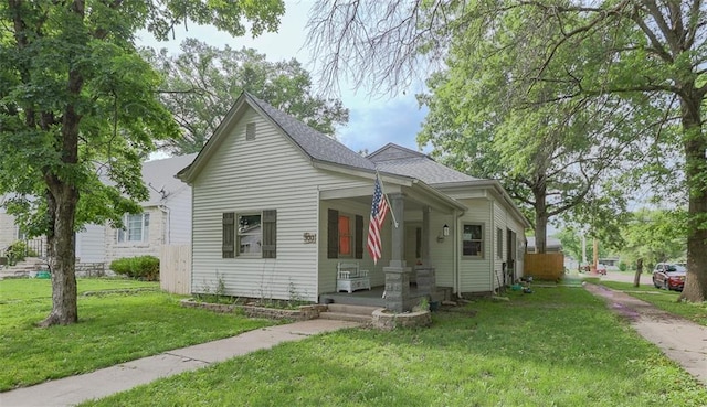 300 Brown Ave, Osawatomie, KS 66064 - bungalow featuring a porch, a front lawn, and a shingled roof
