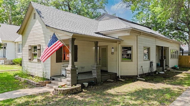 300 Brown Ave, Osawatomie, KS 66064 - view of front of property featuring covered porch, roof with shingles, and a front yard