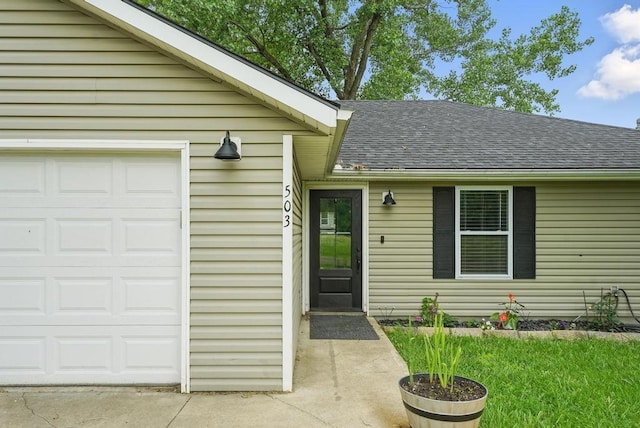 503 N Washington St, East Lynne, MO 64743 - view of exterior entry featuring a garage and a shingled roof