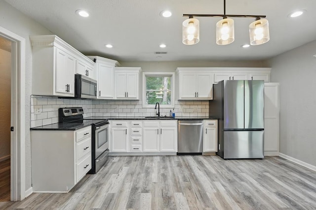 503 N Washington St, East Lynne, MO 64743 - kitchen with stainless steel appliances, dark countertops, light wood finished floors, and recessed lighting