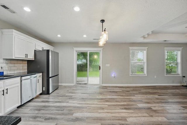 503 N Washington St, East Lynne, MO 64743 - kitchen featuring stainless steel appliances, dark countertops, light wood finished floors, baseboards, and white cabinets