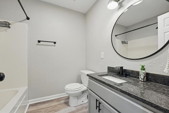 503 N Washington St, East Lynne, MO 64743 - full bathroom with wood finished floors, vanity, toilet, shower / tub combination, and baseboards