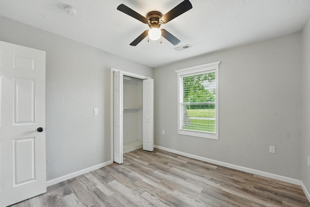 503 N Washington St, East Lynne, MO 64743 - unfurnished bedroom featuring wood finished floors, baseboards, a closet, and a textured wall