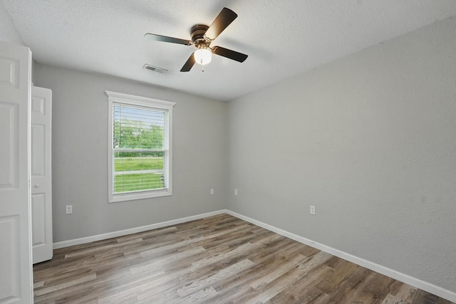 503 N Washington St, East Lynne, MO 64743 - empty room featuring wood finished floors, ceiling fan, baseboards, and a textured ceiling