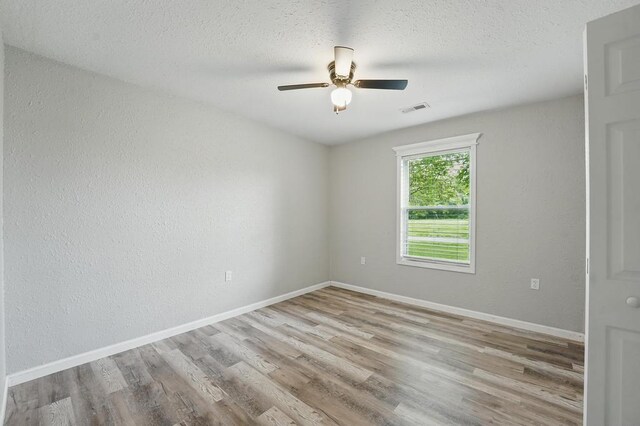 503 N Washington St, East Lynne, MO 64743 - unfurnished room with wood finished floors, ceiling fan, baseboards, and a textured ceiling