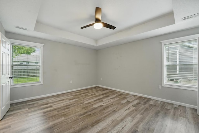503 N Washington St, East Lynne, MO 64743 - empty room featuring wood finished floors, a tray ceiling, baseboards, and ceiling fan