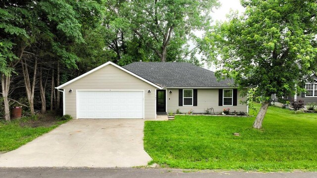 503 N Washington St, East Lynne, MO 64743 - ranch-style home featuring concrete driveway, a garage, a front lawn, and roof with shingles