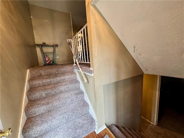 14051 Dunbar Ct, Grandview, MO 64030 - stairs featuring a textured ceiling, vaulted ceiling, baseboards, and carpet