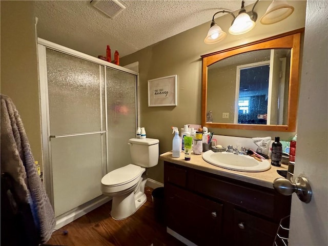 14051 Dunbar Ct, Grandview, MO 64030 - full bathroom with vanity, wood finished floors, a stall shower, toilet, and a textured ceiling