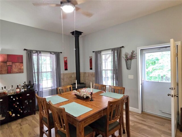 5325 Bryant Bottom Rd, Blackwater, MO 65322 - dining space featuring a wood stove, healthy amount of natural light, a ceiling fan, and light wood-style floors