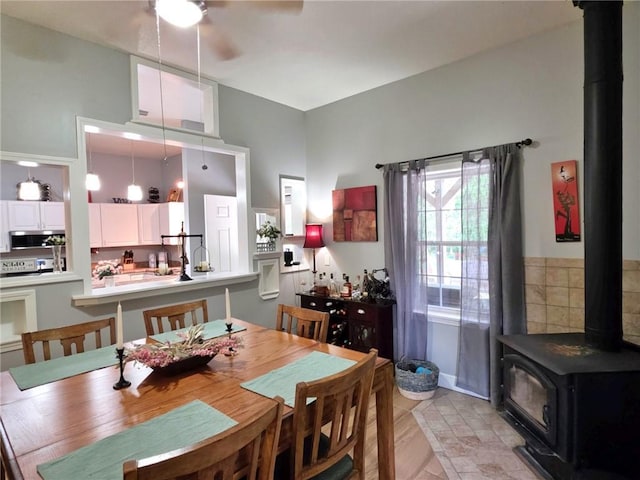 5325 Bryant Bottom Rd, Blackwater, MO 65322 - dining room featuring a wood stove, a ceiling fan, and a high ceiling