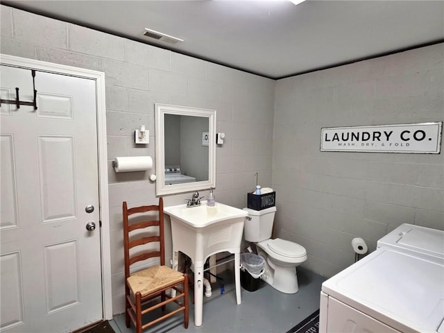 5325 Bryant Bottom Rd, Blackwater, MO 65322 - bathroom featuring washer and clothes dryer, toilet, concrete block wall, and finished concrete floors