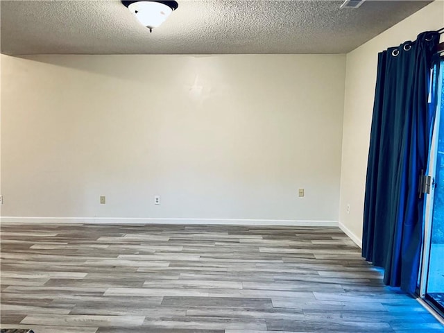 766 Spring Cir, Liberty, MO 64068 - spare room featuring wood finished floors, a textured ceiling, and baseboards