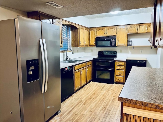 766 Spring Cir, Liberty, MO 64068 - kitchen featuring black appliances, a sink, light wood-type flooring, a textured ceiling, and tasteful backsplash