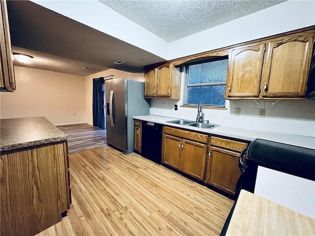 766 Spring Cir, Liberty, MO 64068 - kitchen featuring a sink, black appliances, light wood finished floors, a textured ceiling, and decorative backsplash