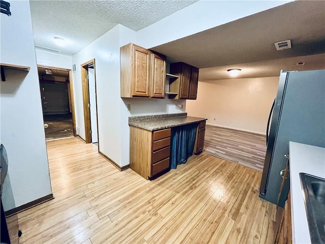 766 Spring Cir, Liberty, MO 64068 - kitchen featuring open shelves, baseboards, light wood-style floors, freestanding refrigerator, and a textured ceiling