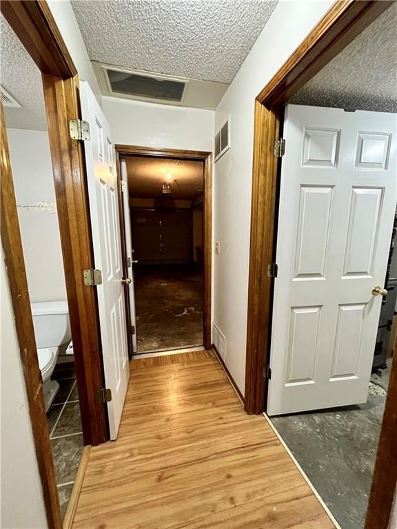 766 Spring Cir, Liberty, MO 64068 - corridor featuring a textured ceiling and light wood-style flooring