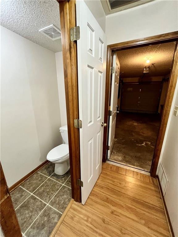 766 Spring Cir, Liberty, MO 64068 - bathroom with toilet, a textured ceiling, wood finished floors, and baseboards