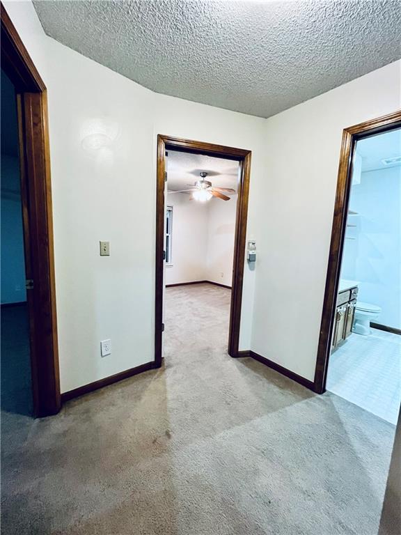 766 Spring Cir, Liberty, MO 64068 - unfurnished room featuring carpet, a textured ceiling, baseboards, and a ceiling fan
