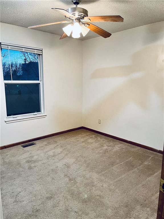 766 Spring Cir, Liberty, MO 64068 - unfurnished room featuring a textured ceiling, carpet, ceiling fan, and baseboards