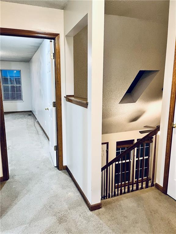 766 Spring Cir, Liberty, MO 64068 - hallway featuring carpet flooring, a textured ceiling, and baseboards