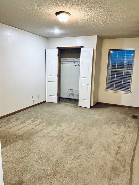 766 Spring Cir, Liberty, MO 64068 - unfurnished bedroom with carpet flooring, a textured ceiling, baseboards, and a closet