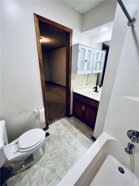 766 Spring Cir, Liberty, MO 64068 - bathroom featuring a textured ceiling, toilet, vanity, and tile patterned flooring