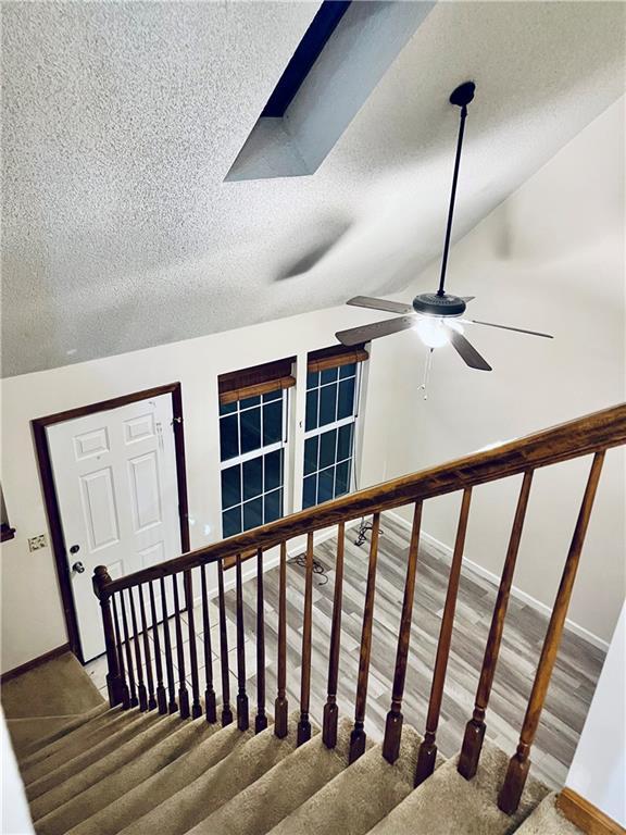 766 Spring Cir, Liberty, MO 64068 - staircase featuring a textured ceiling, baseboards, and a ceiling fan