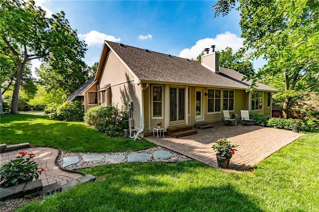 4612 Royal Birkdale Ct, Lawrence, KS 66049 - back of property featuring a chimney, a lawn, a patio, and roof with shingles