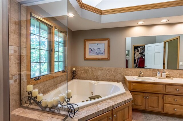 4612 Royal Birkdale Ct, Lawrence, KS 66049 - bathroom featuring a jetted tub, vanity, crown molding, tile patterned flooring, and a spacious closet