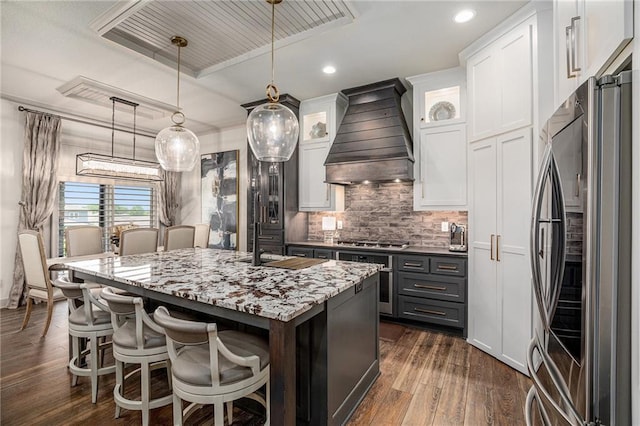15278 W 173rd St, Olathe, KS 66062 - kitchen with appliances with stainless steel finishes, premium range hood, white cabinetry, an island with sink, and recessed lighting