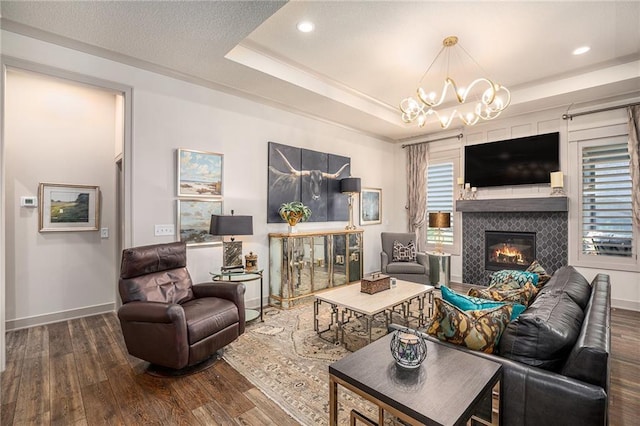 15278 W 173rd St, Olathe, KS 66062 - living area featuring wood finished floors, a glass covered fireplace, recessed lighting, a raised ceiling, and a chandelier