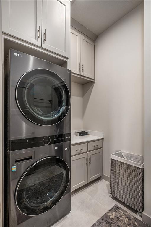 15278 W 173rd St, Olathe, KS 66062 - washroom featuring stacked washer and clothes dryer and cabinet space