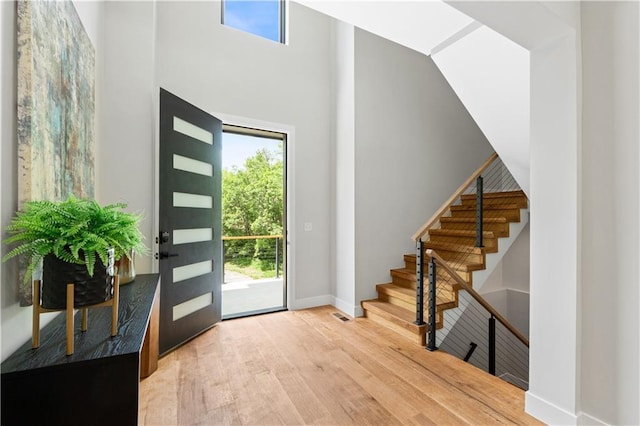 6111 Persimmon Ct, Parkville, MO 64152 - foyer featuring wood finished floors, plenty of natural light, baseboards, a towering ceiling, and stairs