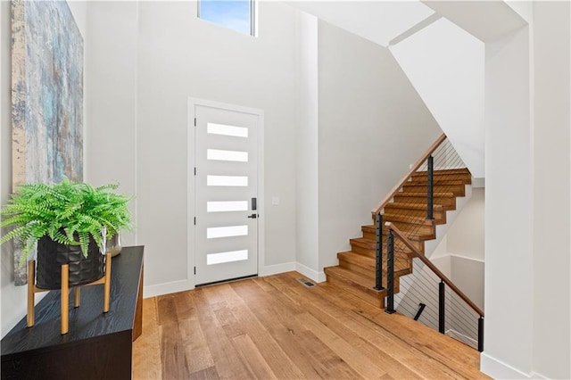 6111 Persimmon Ct, Parkville, MO 64152 - entryway with wood finished floors, a towering ceiling, baseboards, and stairs