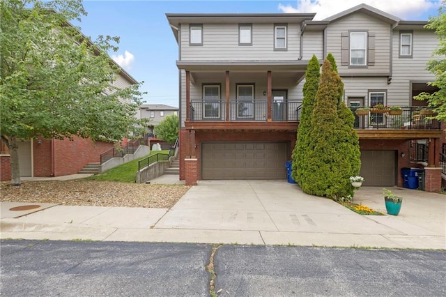 5245 Overland Dr, Lawrence, KS 66049 - townhome / multi-family property featuring a garage, brick siding, driveway, and stairs