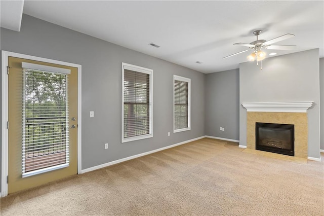 5245 Overland Dr, Lawrence, KS 66049 - unfurnished living room featuring carpet, ceiling fan, baseboards, and a tiled fireplace
