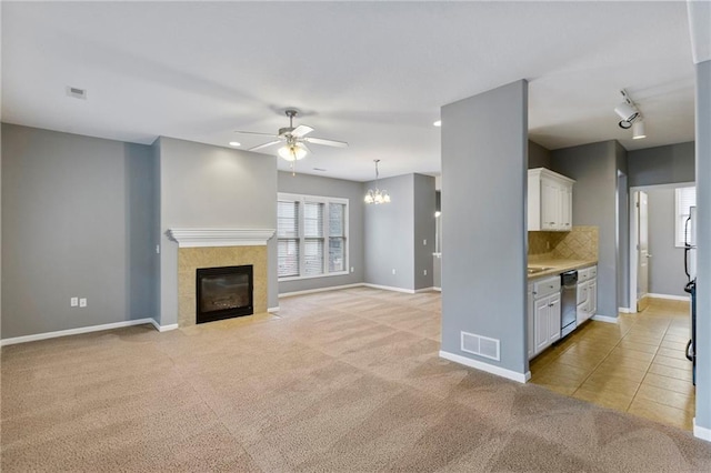 5245 Overland Dr, Lawrence, KS 66049 - unfurnished living room featuring a ceiling fan, light colored carpet, rail lighting, a tile fireplace, and recessed lighting