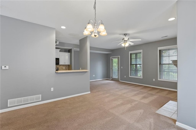 5245 Overland Dr, Lawrence, KS 66049 - unfurnished living room featuring light colored carpet, baseboards, ceiling fan, a chandelier, and recessed lighting