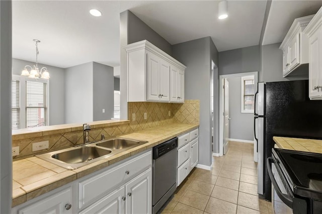 5245 Overland Dr, Lawrence, KS 66049 - kitchen featuring dishwasher, a sink, tile counters, white cabinetry, and decorative backsplash