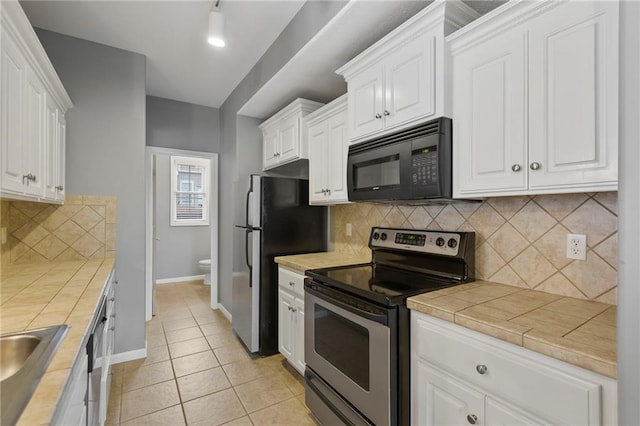 5245 Overland Dr, Lawrence, KS 66049 - kitchen featuring stainless steel appliances, white cabinets, tile countertops, and baseboards