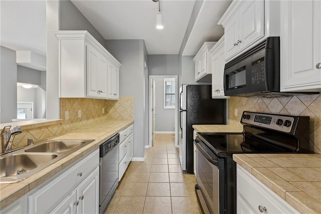5245 Overland Dr, Lawrence, KS 66049 - kitchen with stainless steel appliances, a sink, white cabinetry, baseboards, and tile countertops