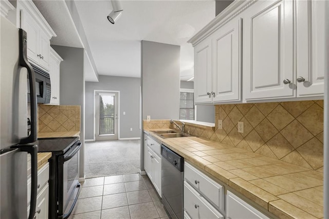 5245 Overland Dr, Lawrence, KS 66049 - kitchen with electric range, dishwashing machine, freestanding refrigerator, tile counters, and a sink